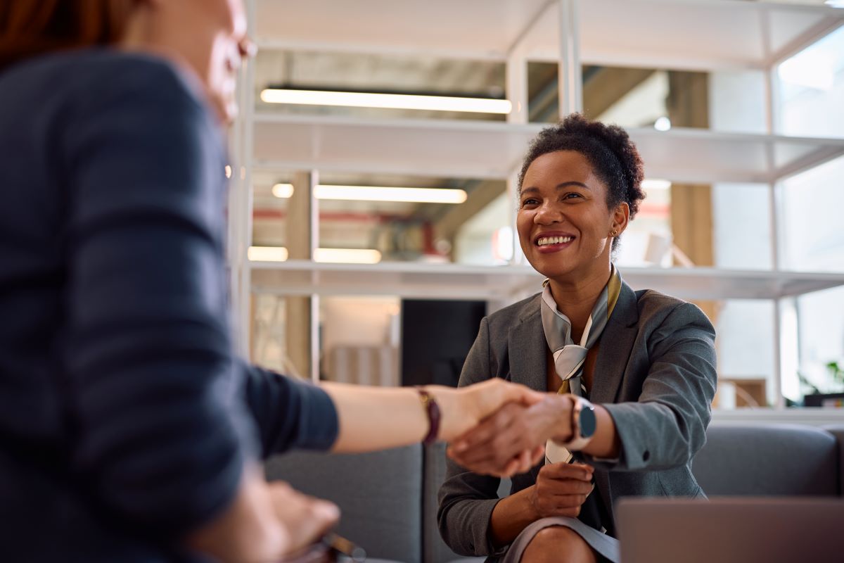 Financial consultant shaking hands with her client in the office.