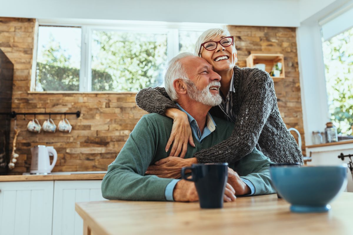 Retired couple embracing at the kitchen 